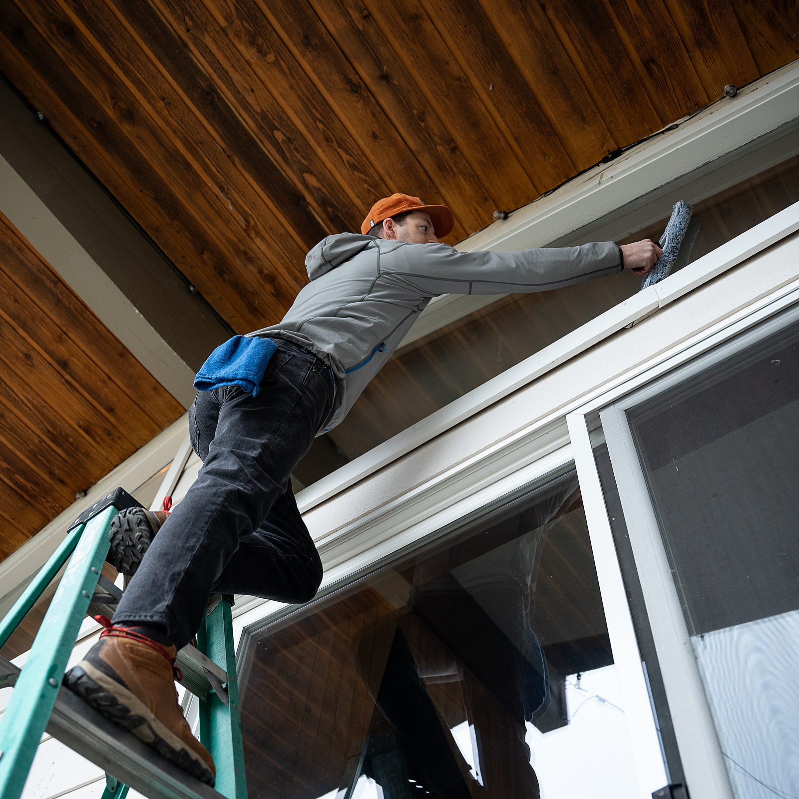 TOPRUNG cleaner detailing exterior glass from a ladder