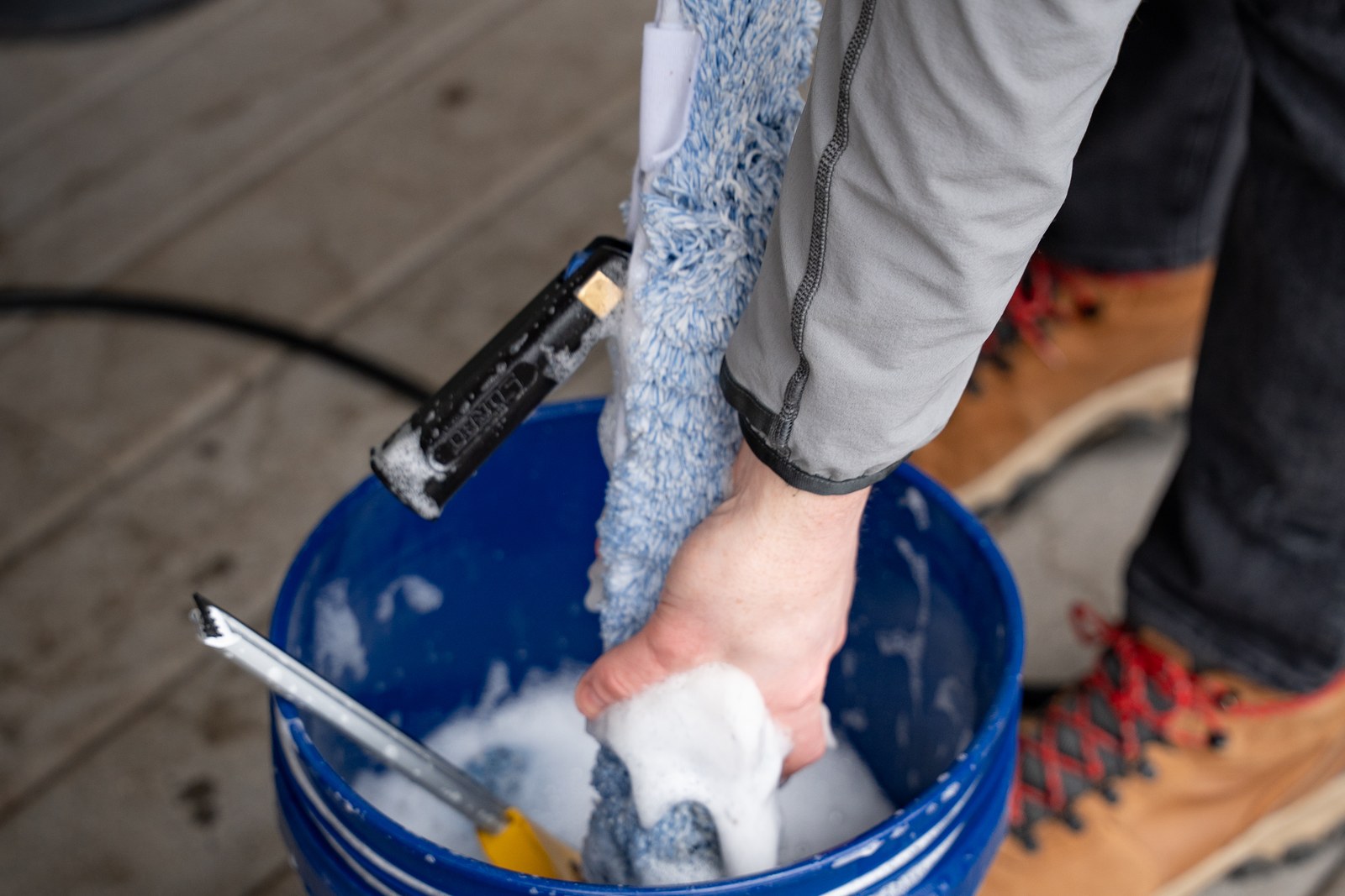 TOPRUNG technician preparing professional window cleaning equipment in a bucket