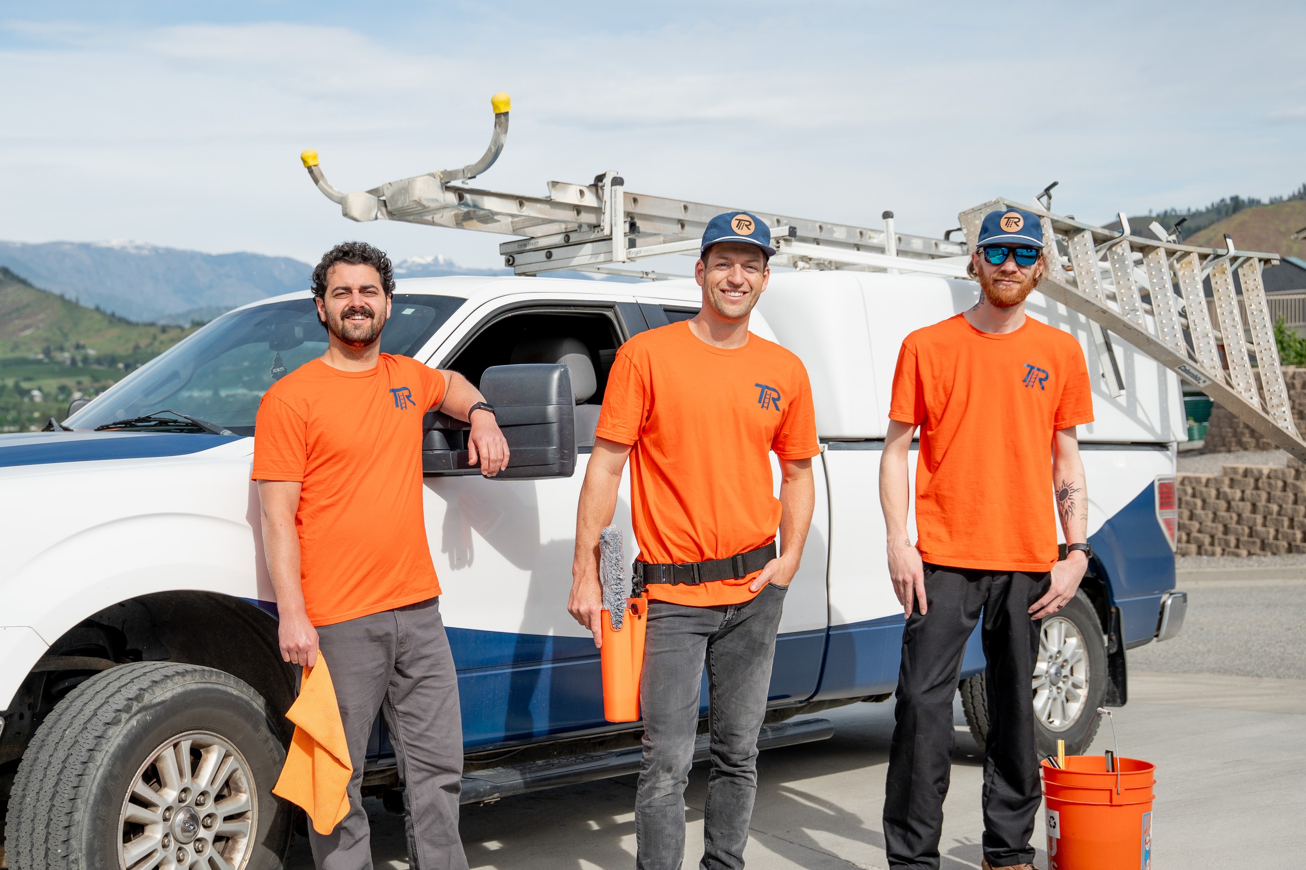 TOPRUNG window cleaning crew standing beside a branded service truck