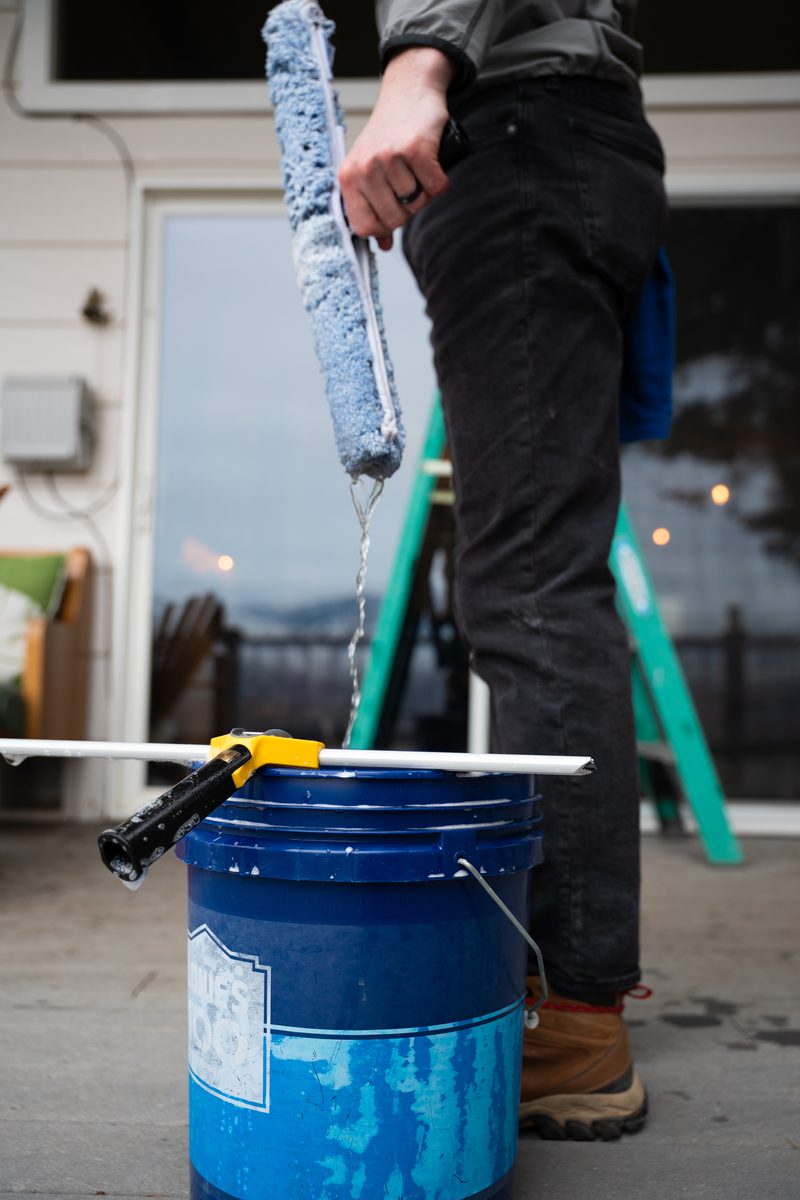 Squeegee mop dripping water over cleaning bucket - detail work